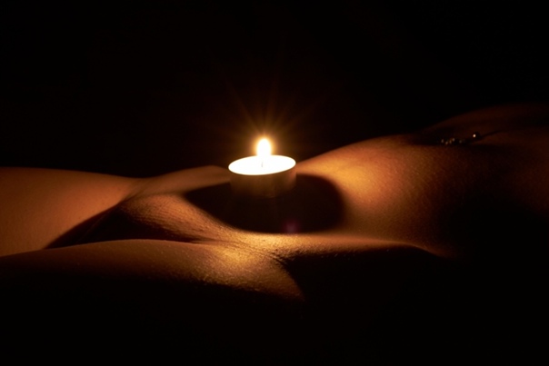 Рыжая девушка при свете свечи с голыми сисечками фото
